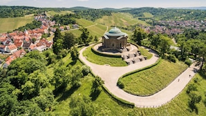 A historic building with a dome, surrounded by a landscaped garden and a winding path.
