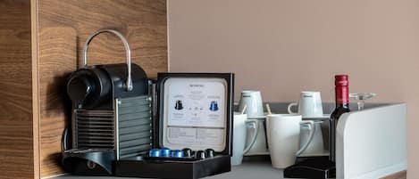 A coffee machine with a manual and several coffee cups on a counter.