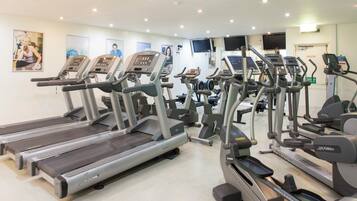 A gym with multiple treadmills, ellipticals, and a stationary bike.