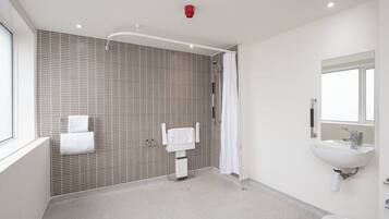A modern bathroom with a shower, a sink, and a toilet.