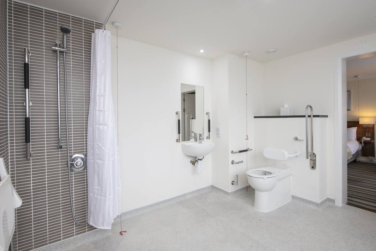 A modern bathroom with a shower, toilet, and sink.