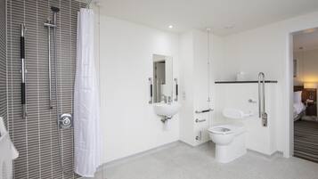 A modern bathroom with a shower, toilet, and sink.