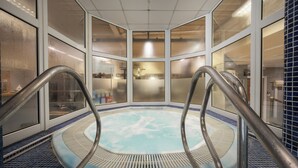 A hot tub with metal railings, surrounded by frosted glass windows and a tiled floor. - Holiday Inn Norwich by IHG (Norwich)