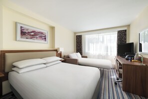 A hotel room with two beds, a desk, a television, and a window with curtains. - Holiday Inn Norwich by IHG (Norwich)