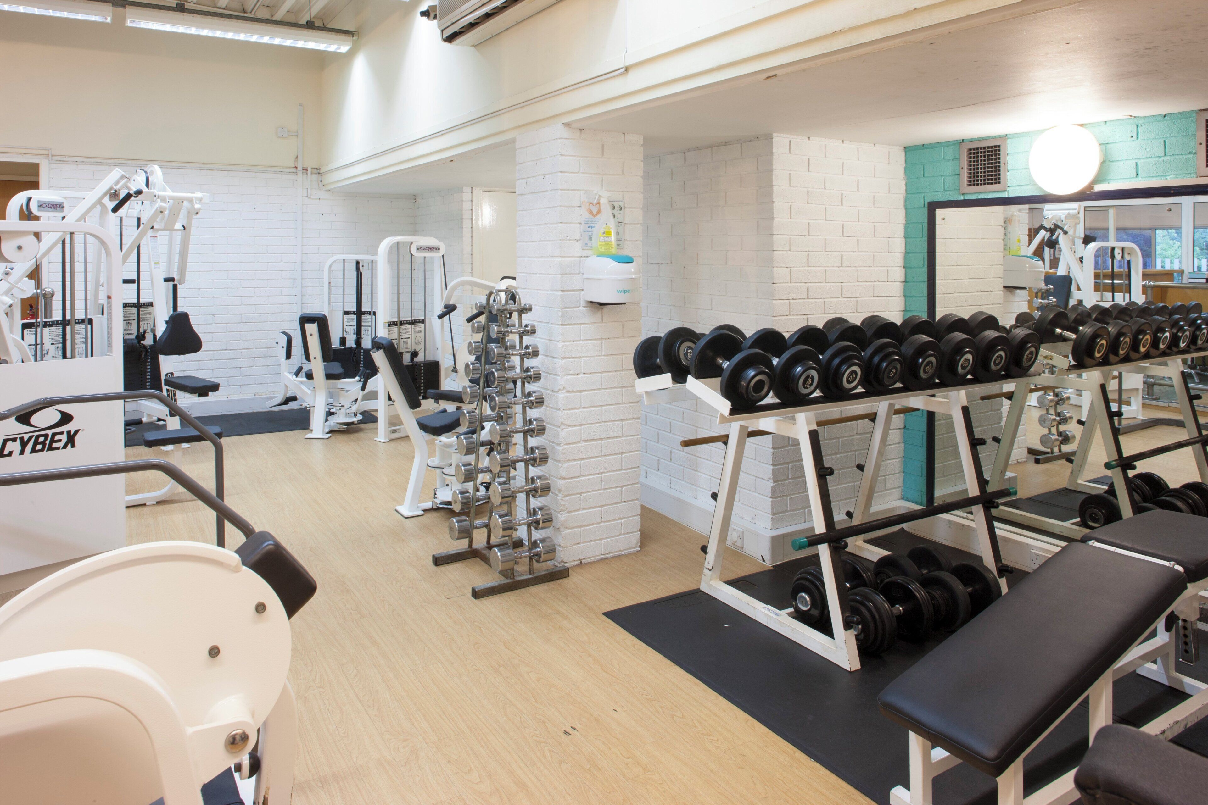 A gym with various exercise equipment, including dumbbells and weight machines.