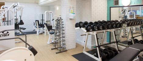 A gym with various exercise equipment, including dumbbells and weight machines.
