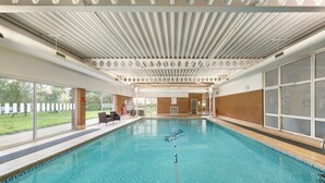 A large indoor swimming pool with a view of a grassy area outside. - Holiday Inn Norwich by IHG (Norwich)