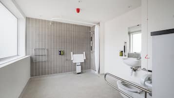 A modern bathroom with a shower, toilet, and sink.