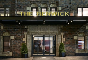 Het uiterlijk van hotel The Renwick, met een opvallende entree, grote ramen en een bakstenen gevel.