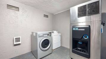 Una sala de lavandería con lavadora, secadora y dispensador de hielo.