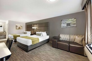 Une chambre d’hôtel avec deux lits, un canapé, un bureau et une salle de bain.