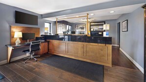 A modern kitchen with a wooden island, a built-in stove, and a flat-screen TV above the counter.