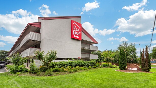 A Red Roof Inn with a modern architectural design, featuring a prominent red and white sign, a well-maintained lawn, and a parking area. - Red Roof Inn Durham - Duke Univ Medical Center (Durham)