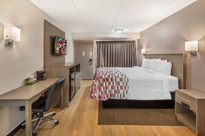 A hotel room with a bed, desk, chair, and a television mounted on the wall. - Red Roof Inn Durham - Duke Univ Medical Center (Durham)