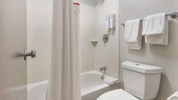 A bathroom with a bathtub, toilet, and a shower curtain.