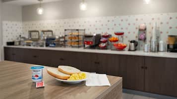 A breakfast bar with a container of Dannon yogurt, scrambled eggs, and toast.