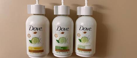 Tres productos de cuidado personal Dove sobre un fondo neutro.