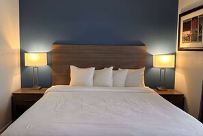 Relax in comfort with a large bed, bedside tables, and a wooden headboard.