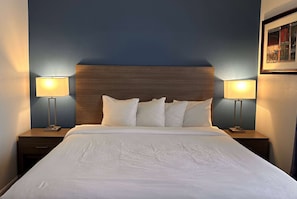 Relax in comfort with a large bed, bedside tables, and a wooden headboard.