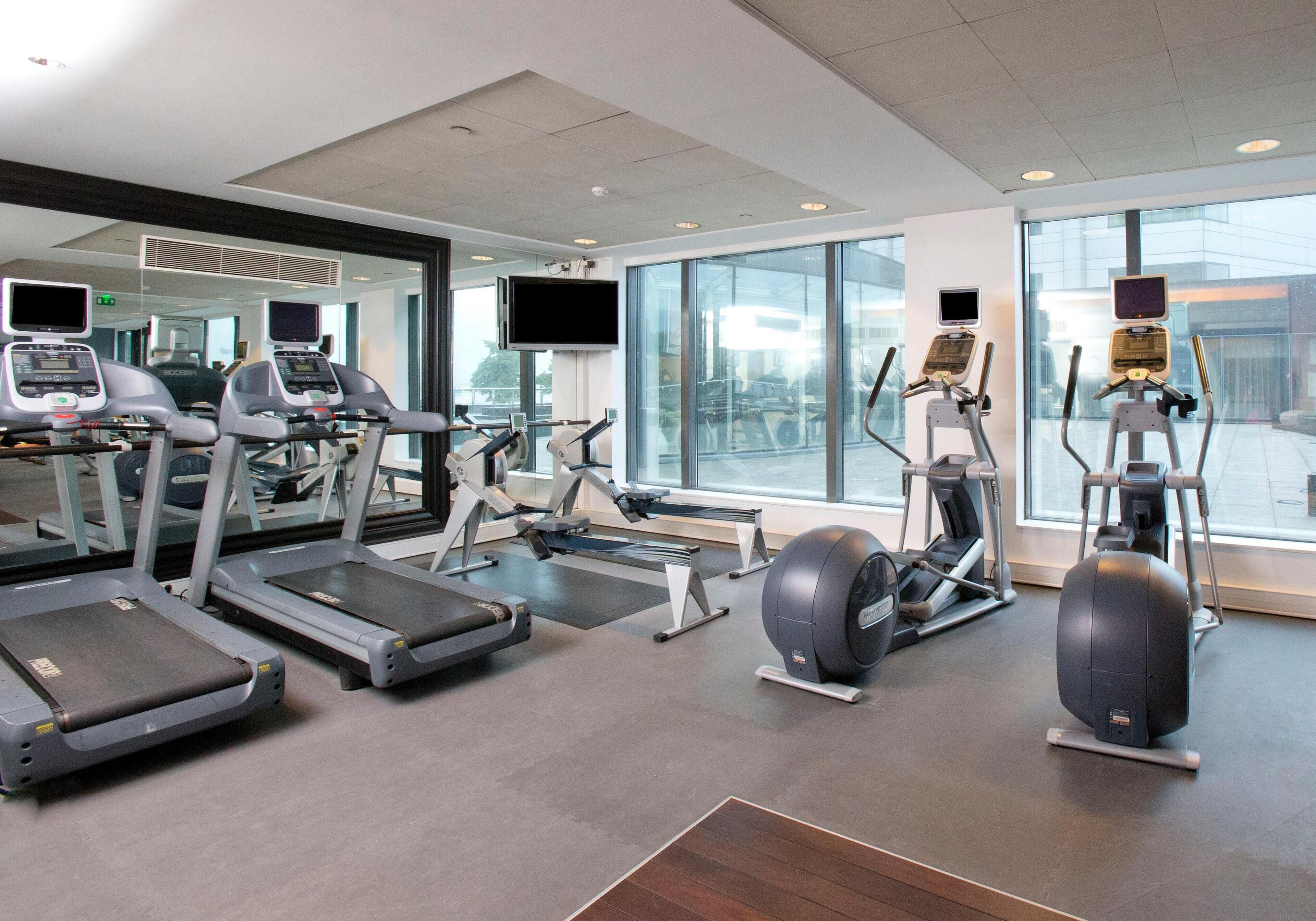 A gym with treadmills, elliptical machines, and a rowing machine.