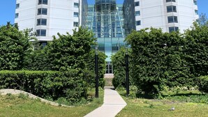 Un hotel moderno con dos edificios idénticos, una estructura central de vidrio y un camino que conduce a la entrada.