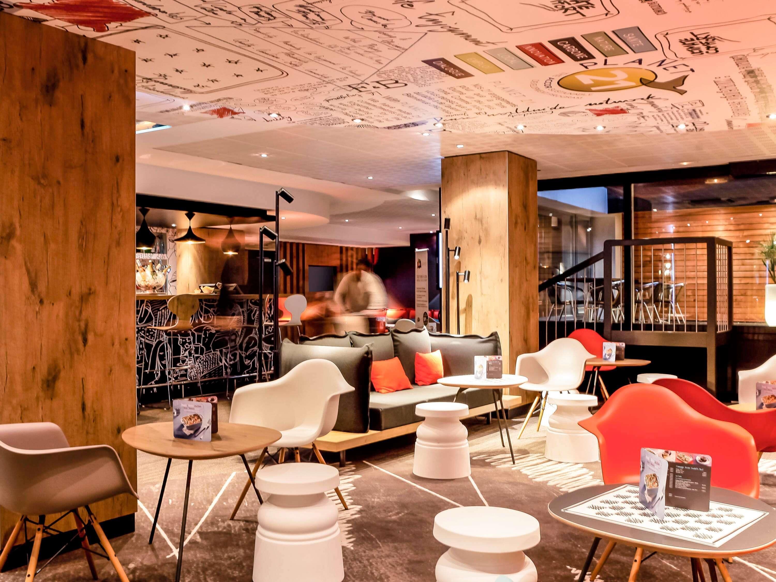 Un intérieur moderne comprenant un bar, des espaces de détente et un escalier.