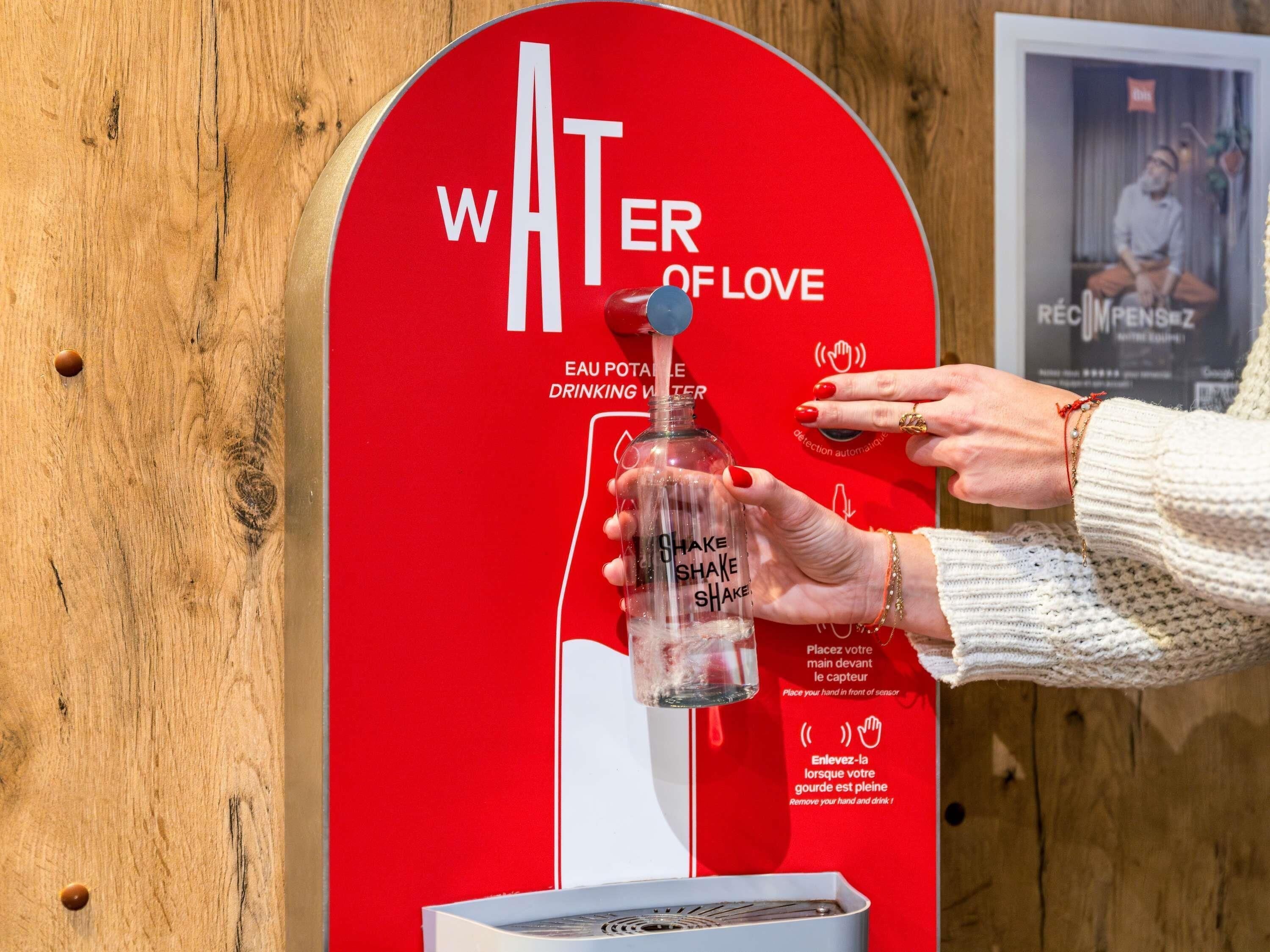 A hand-operated water dispenser with instructions in multiple languages.