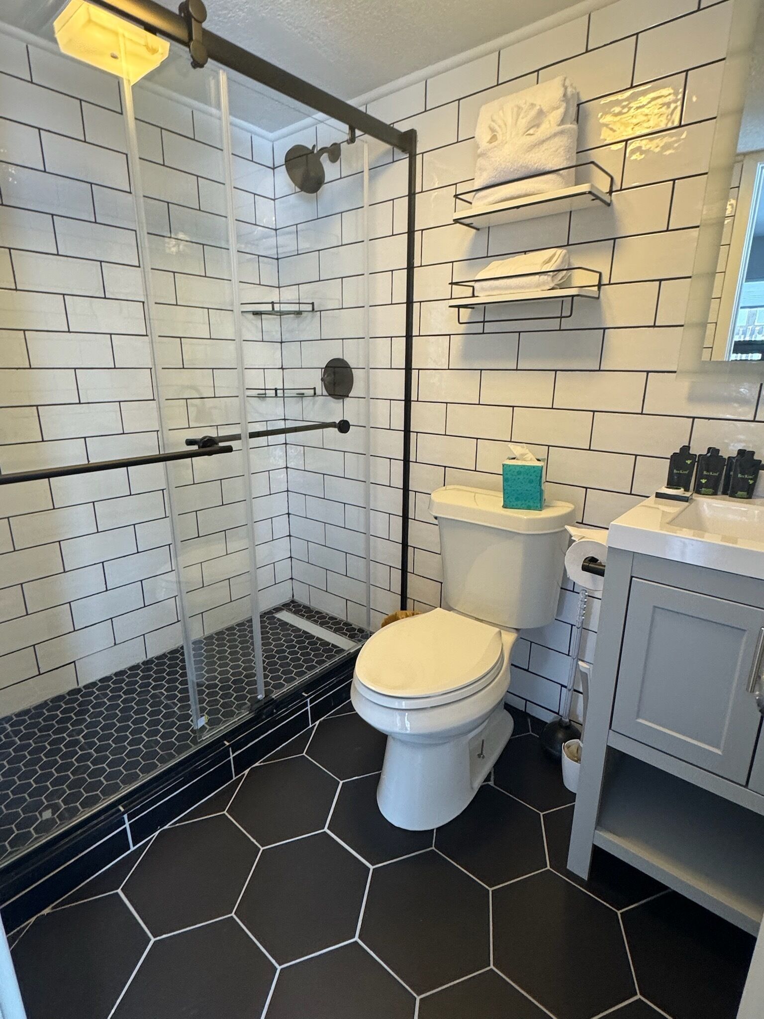 A bathroom with a shower, toilet, and sink.