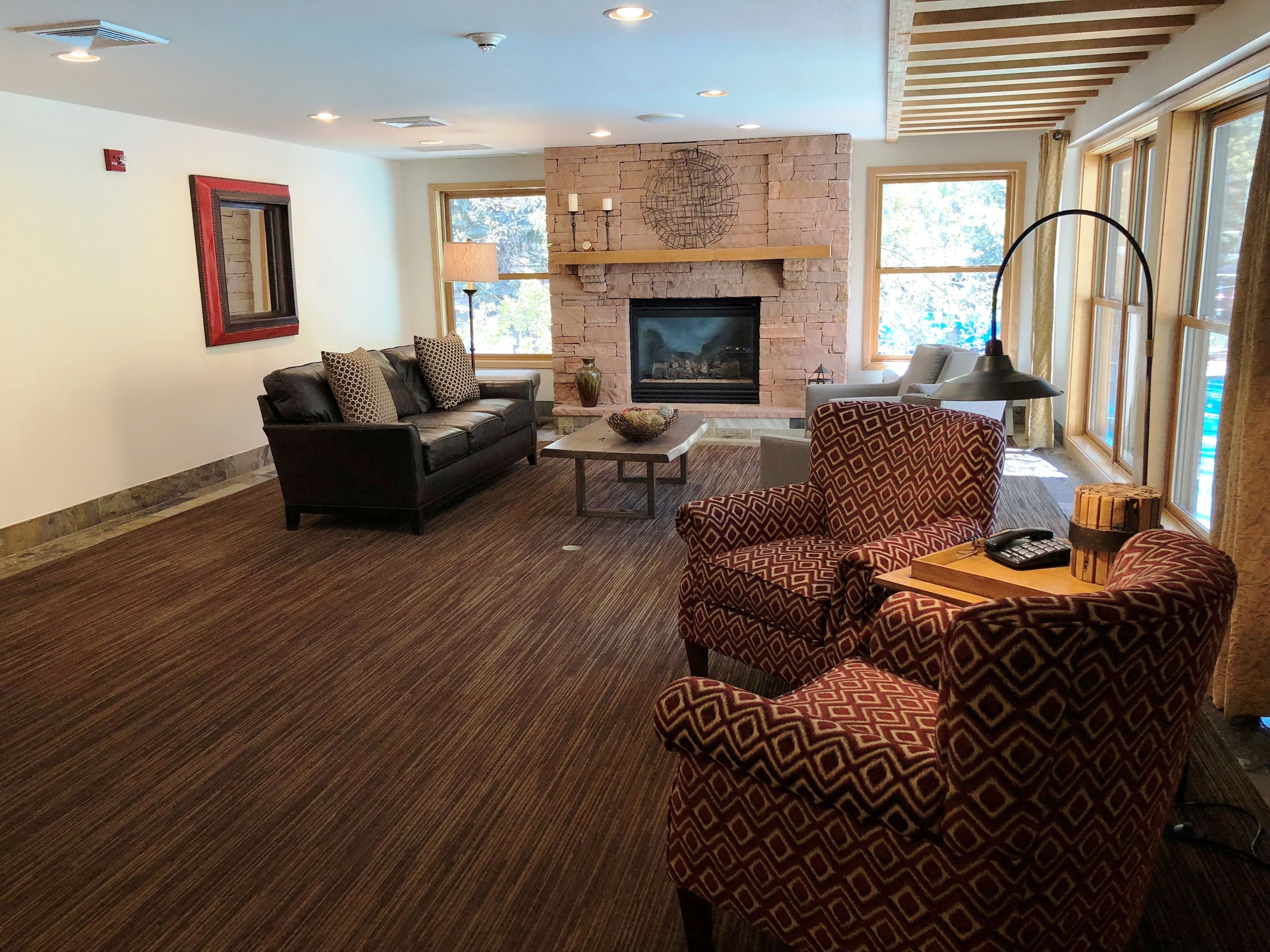 A living room with a fireplace, a sofa, a patterned armchair, and a coffee table.