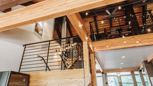A wooden interior with a staircase, seating area, and a view through a window. - Vail Racquet Club Mountain Resort (Vail)