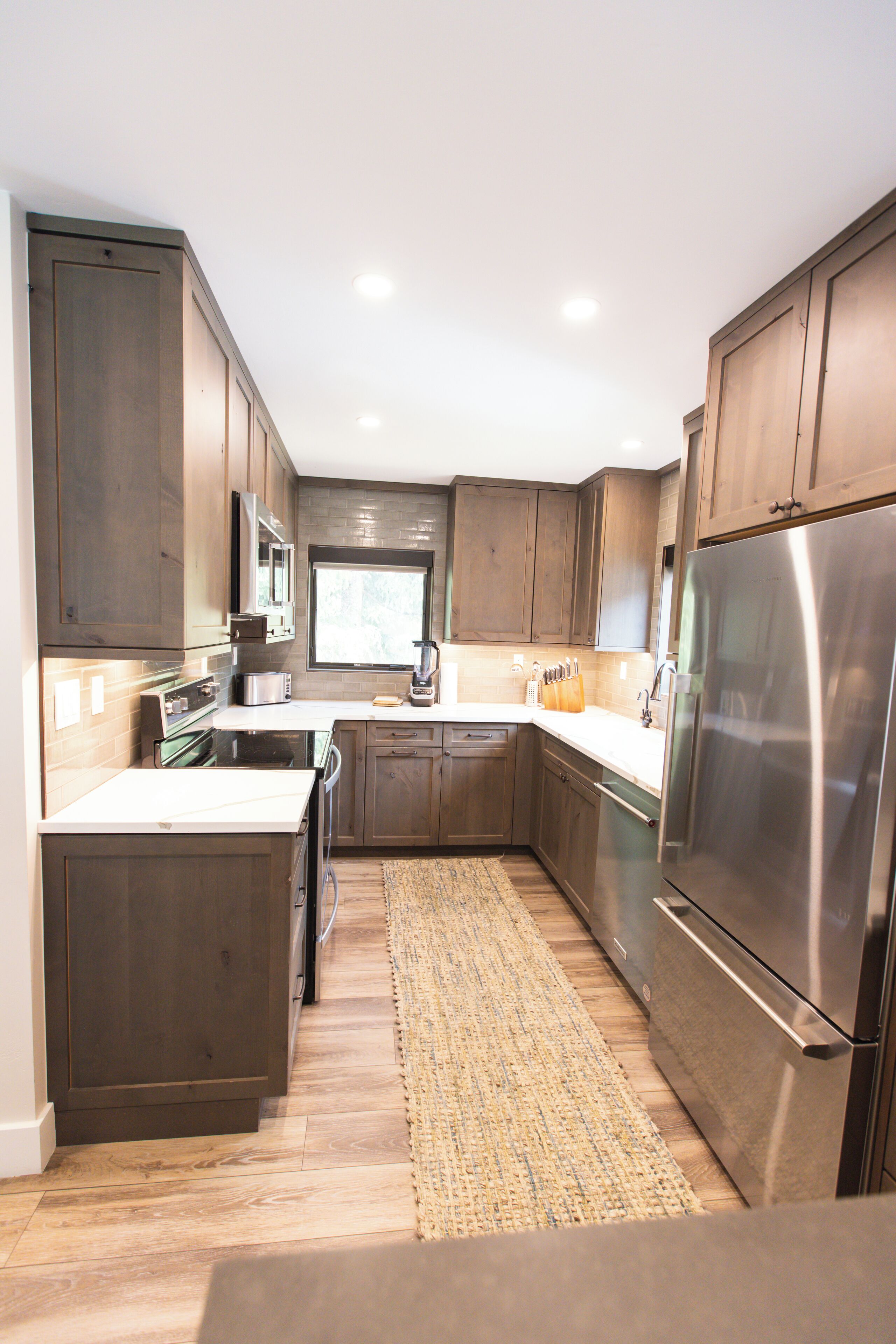A modern kitchen with wooden cabinets, stainless steel appliances, and a central island.