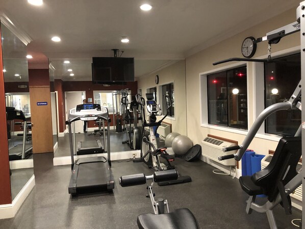 A gym with treadmills, elliptical machines, and free weights. - Holiday Inn Express Hotel & Suites Corning by IHG (Corning)