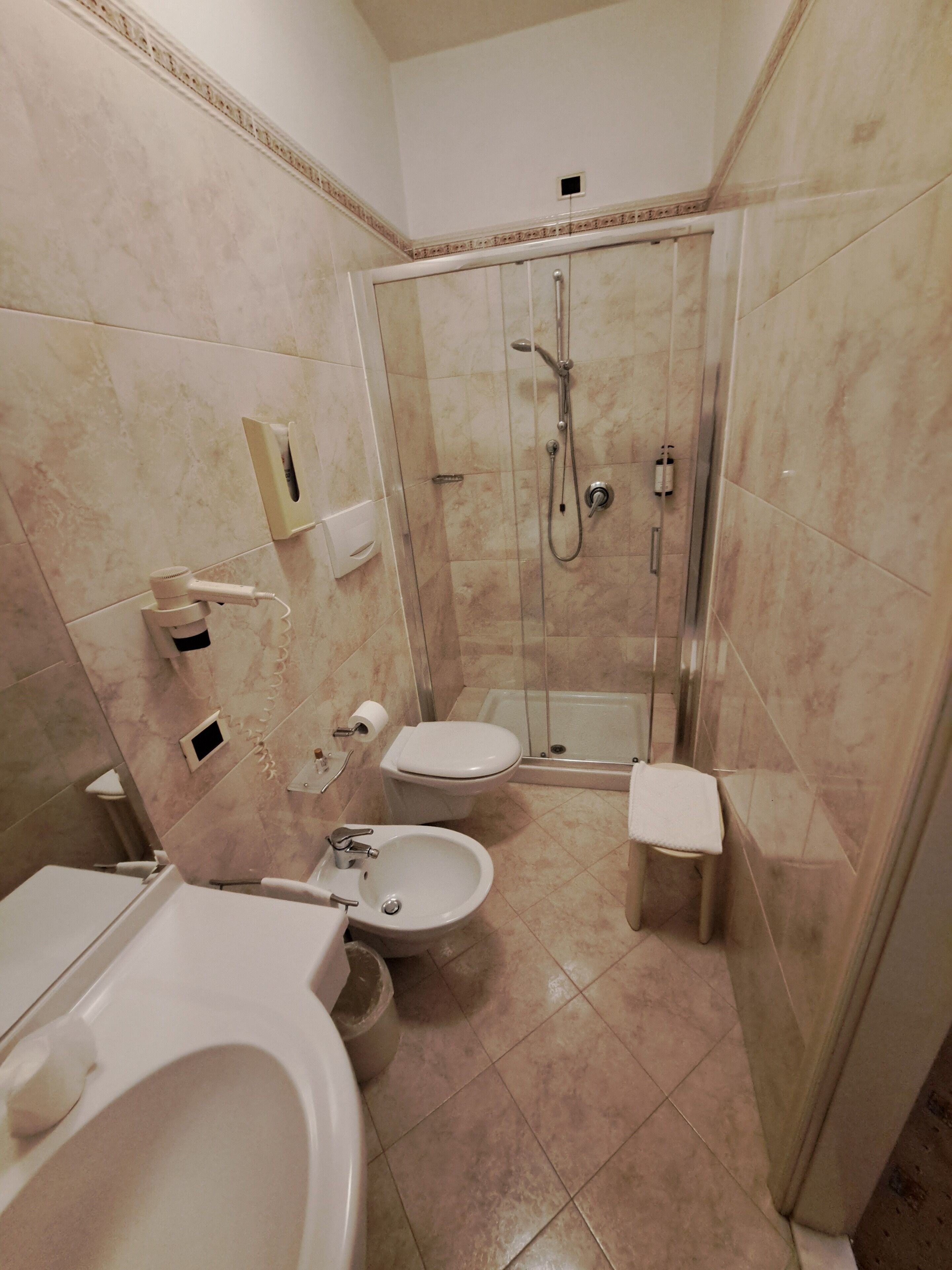 Un baño equipado con ducha, inodoro, bidé y lavamanos.