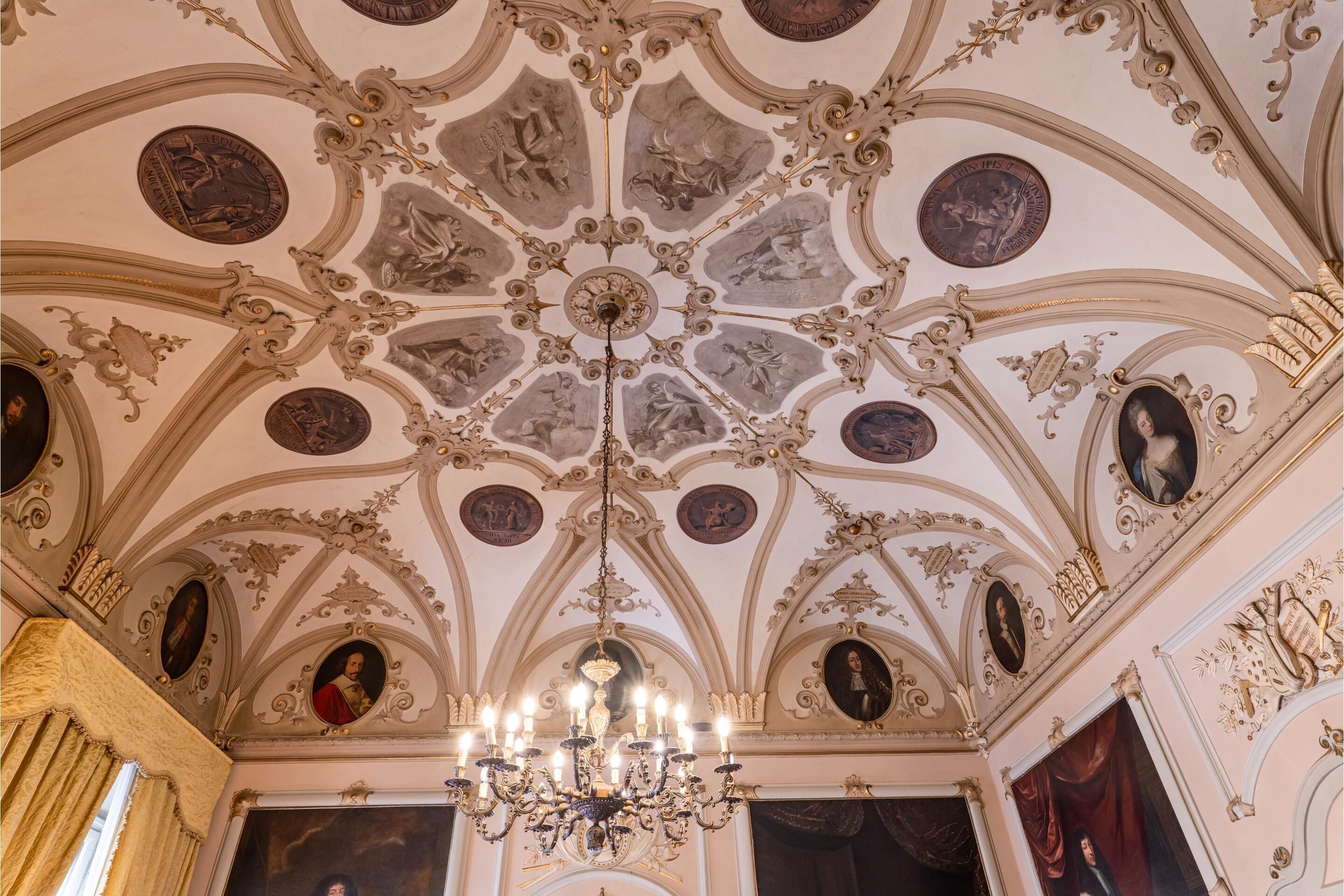An ornate ceiling with intricate designs and a chandelier.