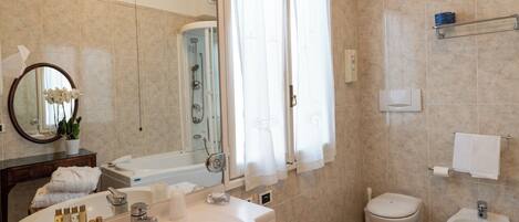 Un baño moderno con bañera, inodoro, bidé y lavabo.