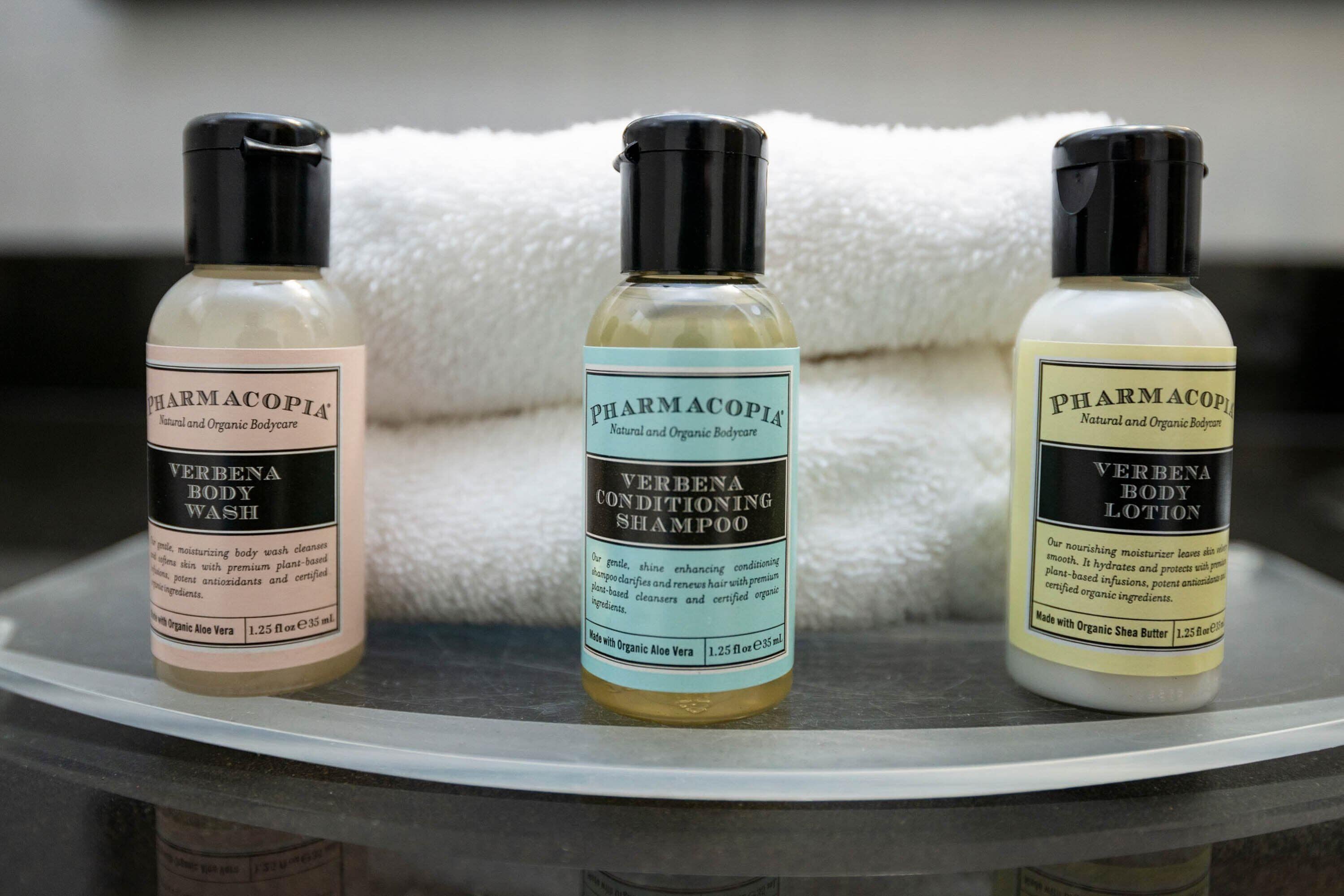 Three bottles of Verben body wash, shampoo, and lotion on a shelf.