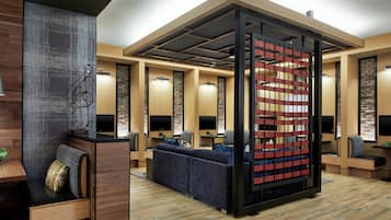 A modern interior with a sectional sofa, wooden flooring, and a decorative partition with a grid pattern.