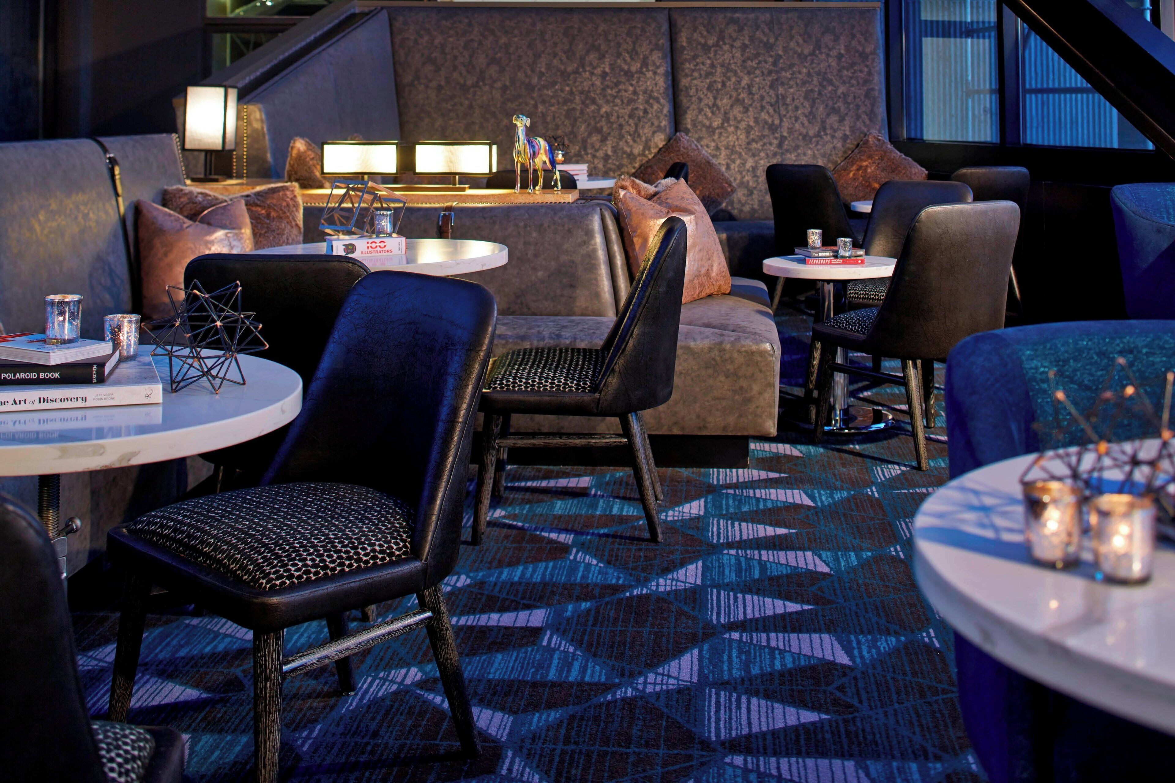 A modern lounge area with leather seating, a patterned carpet, and ambient lighting.