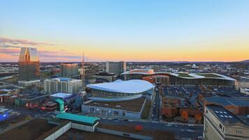 A cityscape with modern buildings, a large stadium, and a mix of commercial and residential areas.