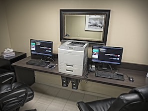 A hotel reception desk with two computer monitors, a printer, and a telephone. - Holiday Inn Hotel & Suites Anaheim by IHG (Anaheim)