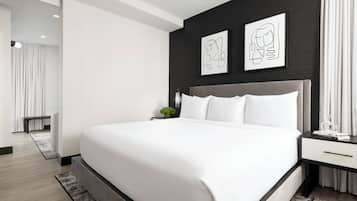 Een moderne slaapkamer met een groot bed, een nachtkastje en twee ingelijste kunstwerken aan de muur.