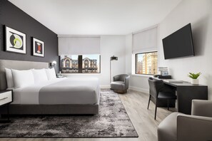 Une chambre d’hôtel moderne équipée d’un grand lit, d’un bureau, d’une chaise et d’une télévision.