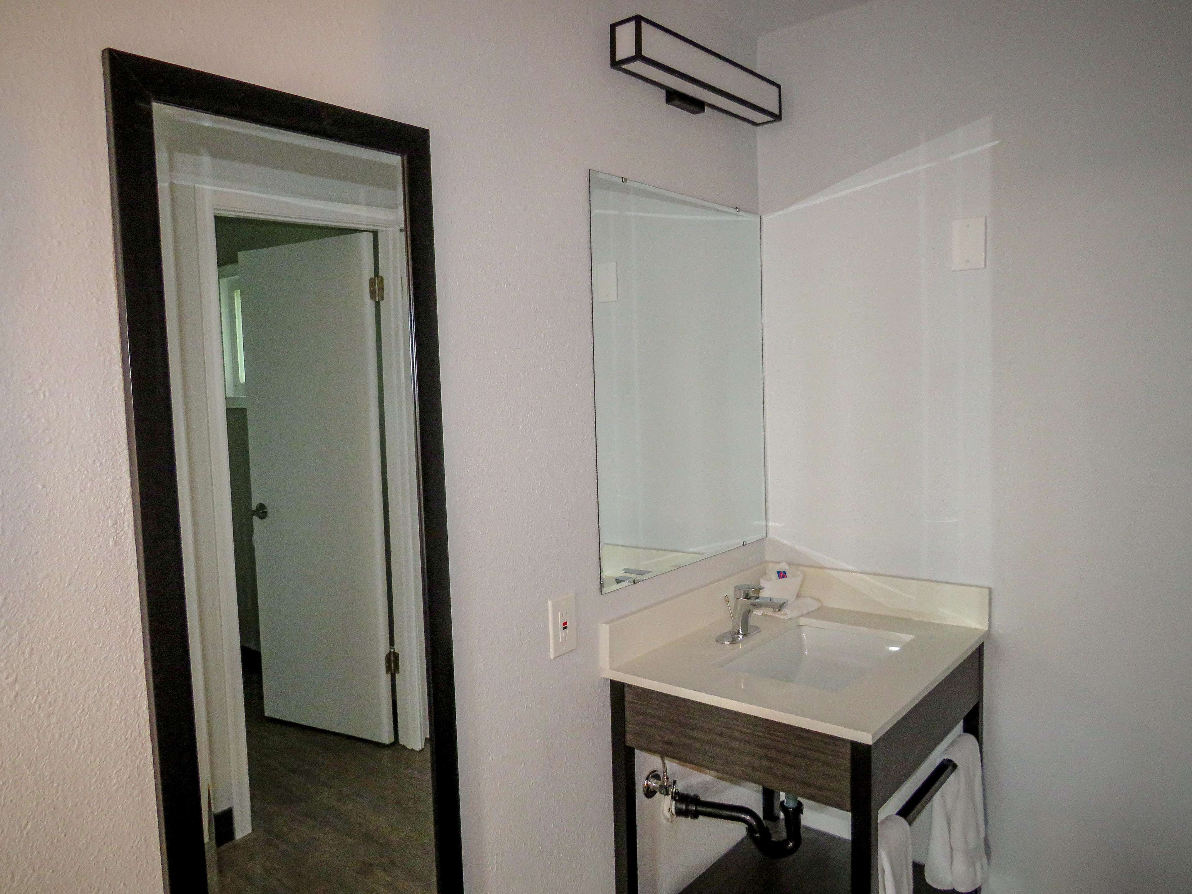 Une salle de bain avec un lavabo blanc, un miroir et un porte-serviettes.