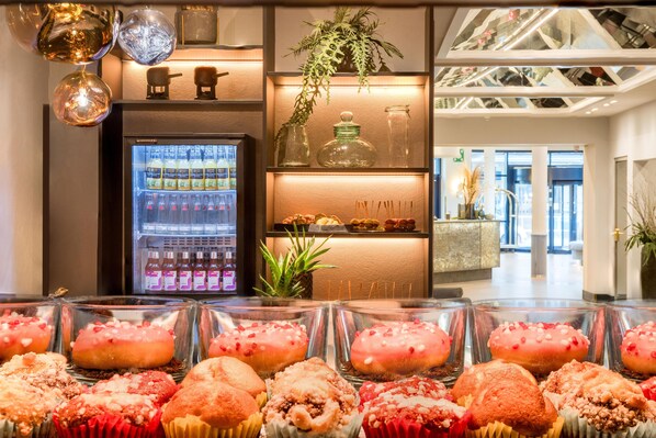 A bakery display with various pastries and a refrigerated beverage cooler.