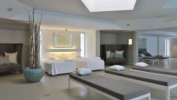 A modern spa room with a large skylight, a massage table, a lounge area, and a decorative plant.