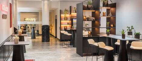 Un interior moderno con una zona de bar, asientos y una mesa de recepción.