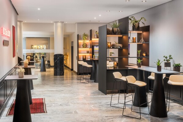 Un interior moderno con una zona de bar, asientos y una mesa de recepción.