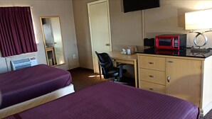 A hotel room with two beds, a desk, a chair, a microwave, a TV, and a wardrobe. - Best Budget Inn (Tell City)