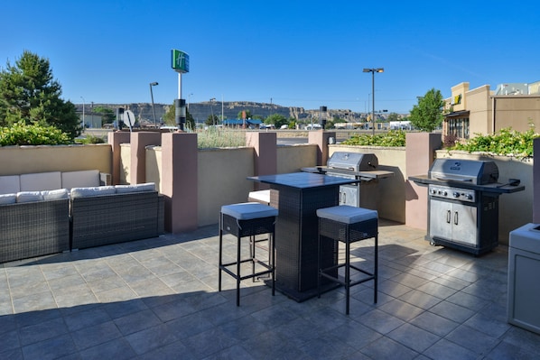 An outdoor patio with a grill, seating, and a view of the city. - Holiday Inn Express Farmington - Bloomfield by IHG (Farmington)