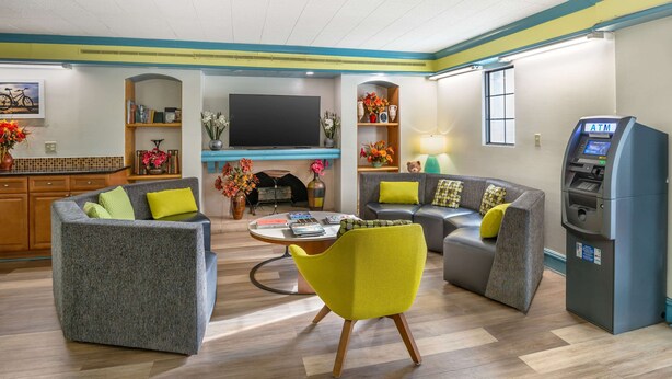 A modern living room with sofas, a TV, and an ATM. - Econo Lodge Richmond-North Chesterfield (Richmond)